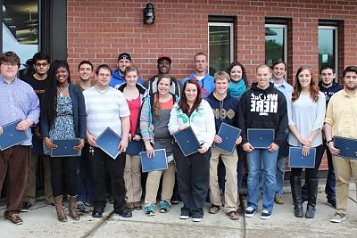 Group of students standing outside Landmark College building holding awards